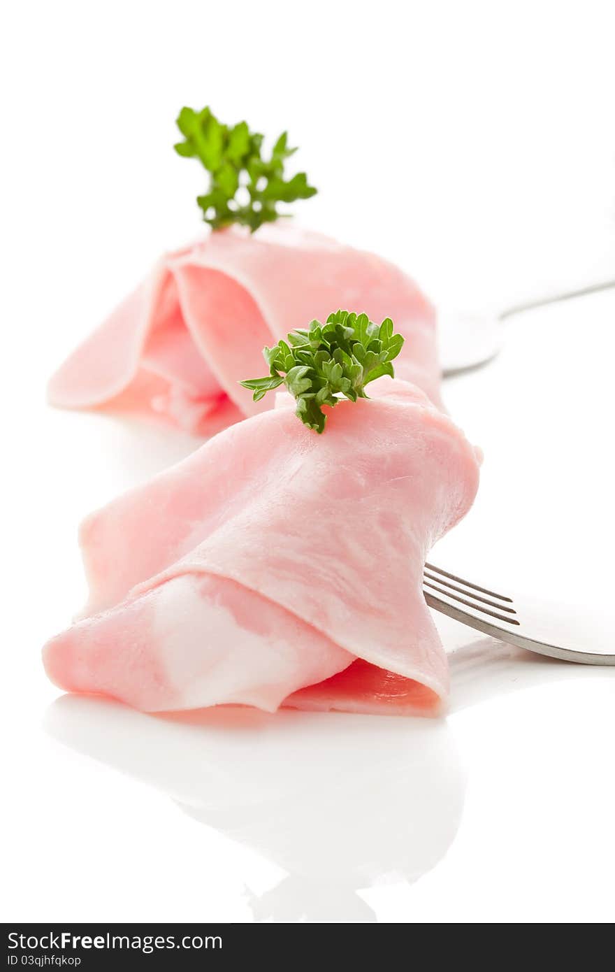 Photo of delicious ham sliced wrapped on fork over white background. Photo of delicious ham sliced wrapped on fork over white background