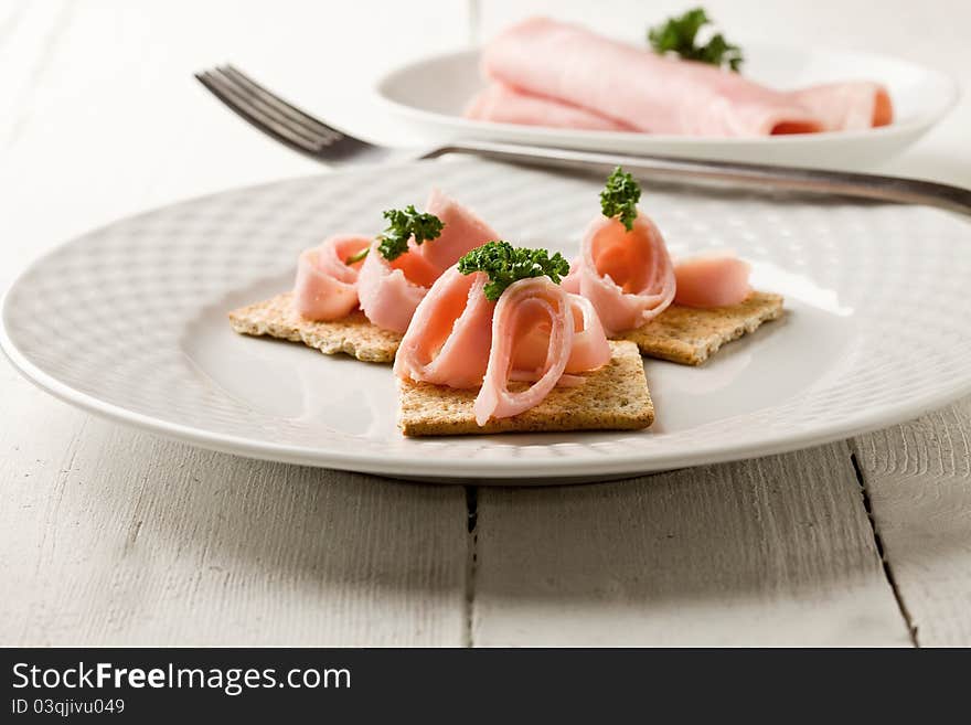 Crackers canapes with ham and parsley