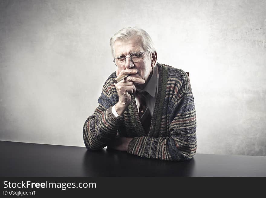 Portrait of a senior man smoking a cigar. Portrait of a senior man smoking a cigar