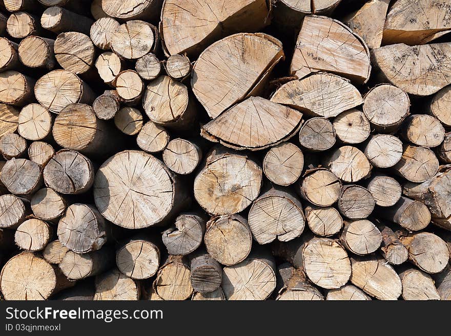 Dry chopped firewood logs stacked up on top of each other in a pile