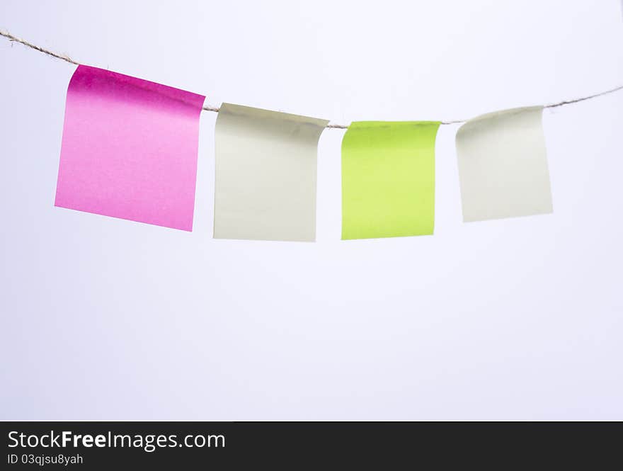 Multi-colored Post-it note paper hanging from clothesline. Multi-colored Post-it note paper hanging from clothesline