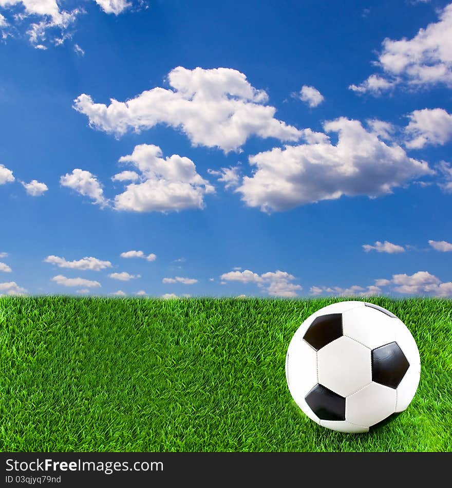 Football on grass, with beautiful sky above it