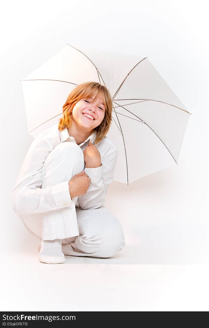 Blonde girl in white wear sitting with white umbrella and smiling overwhite. Blonde girl in white wear sitting with white umbrella and smiling overwhite