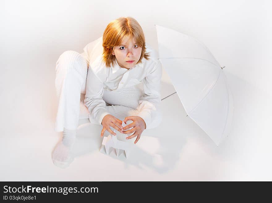 Girl in white sitting and making card house overwhite horizontal. Girl in white sitting and making card house overwhite horizontal