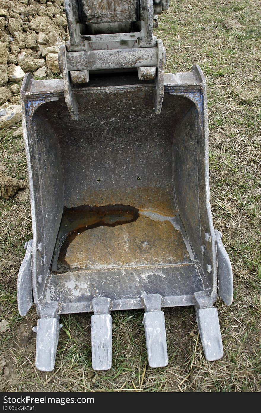 An excavator shovel, standing on the ground. An excavator shovel, standing on the ground