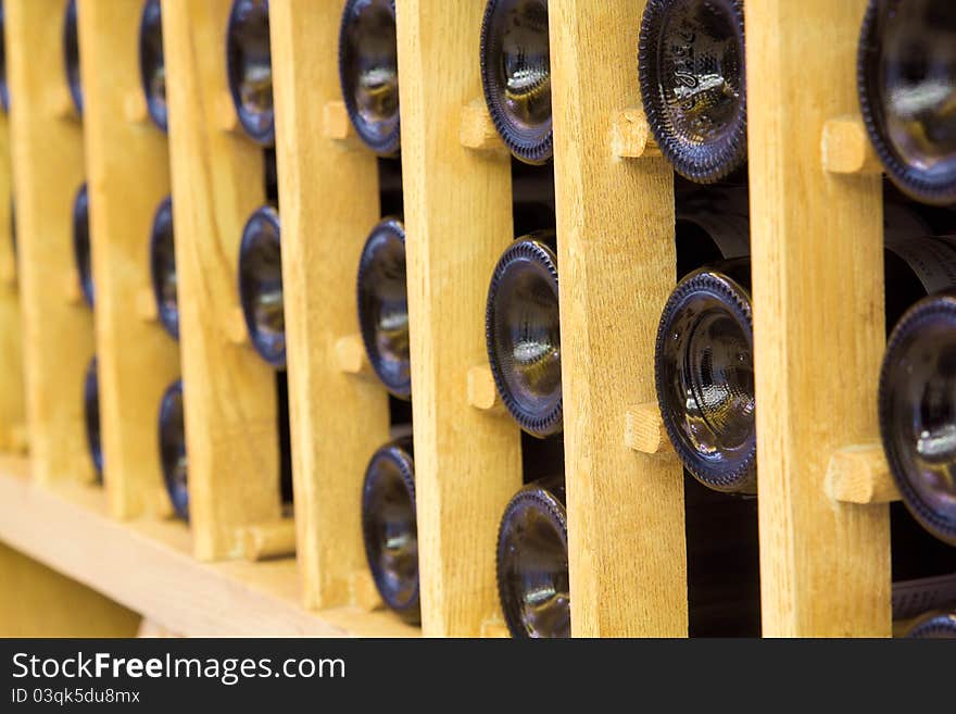 Snapshot of the wine cellar. The bottles on wooden shelves.