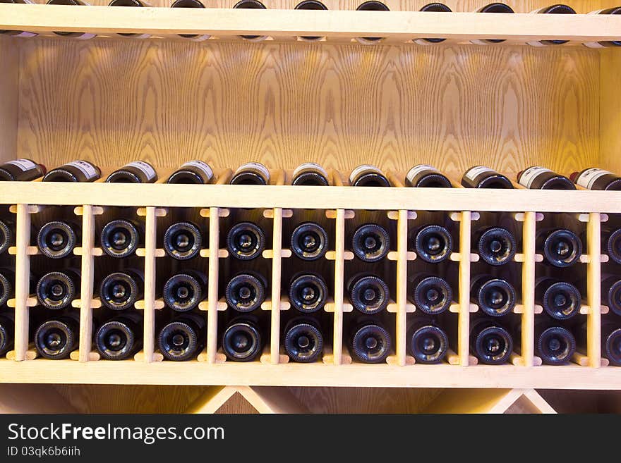 Snapshot of the wine cellar. The bottles on wooden shelves.