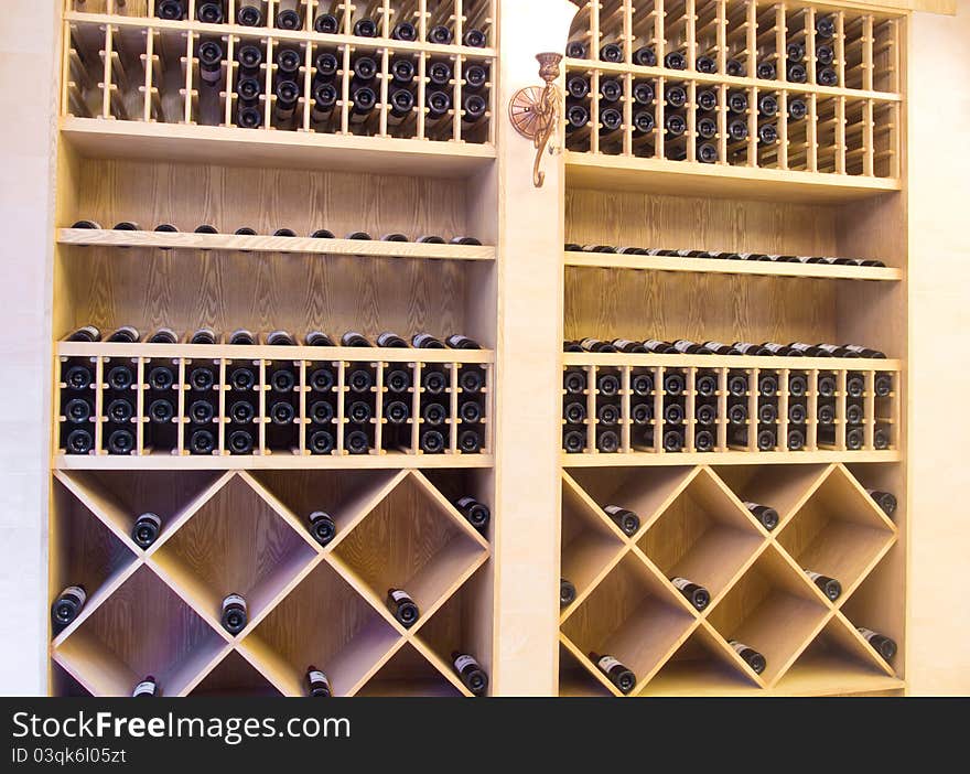 Snapshot of the wine cellar. The bottles on wooden shelves.