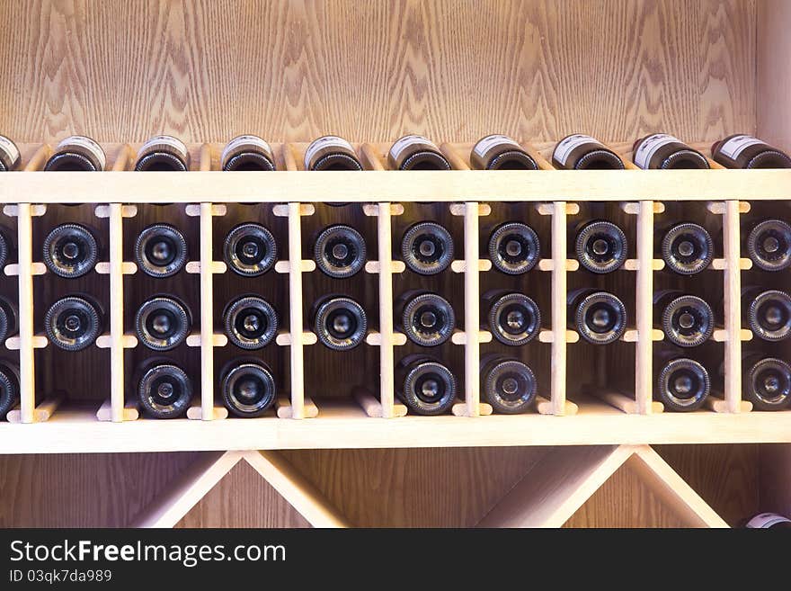 Snapshot of the wine cellar. The bottles on wooden shelves.