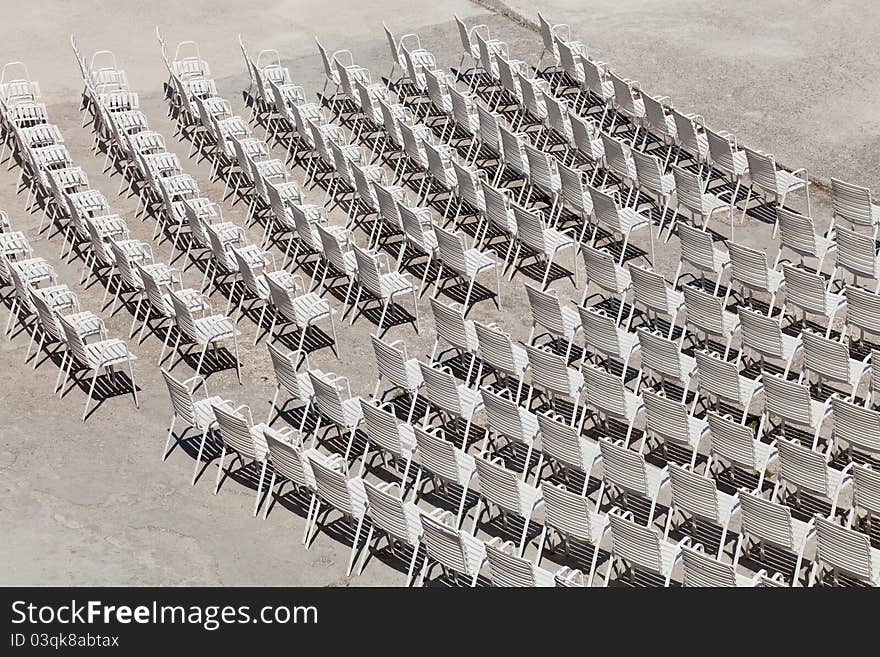 White plastic chairs set for an outdoor event.