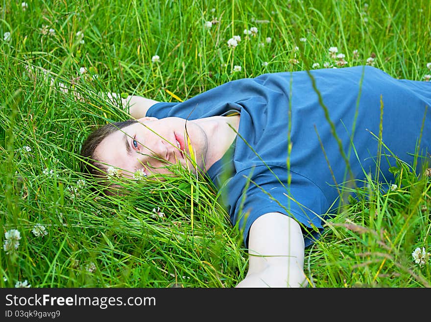 Young man lying on the green grass. Young man lying on the green grass