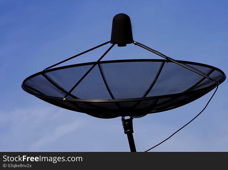 Photo of back satellite with blue sky.