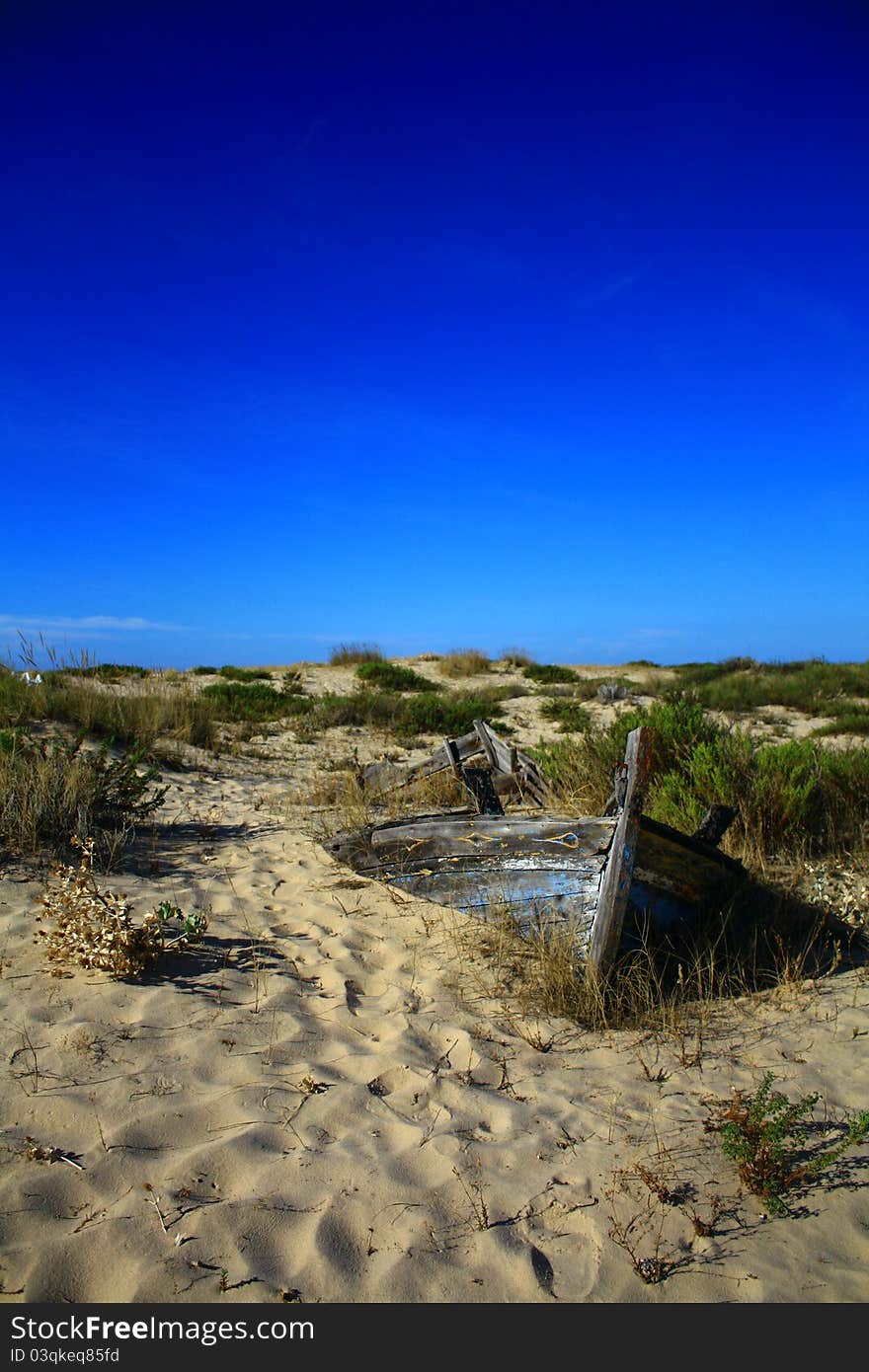 A fishing boat stranded on the sand.