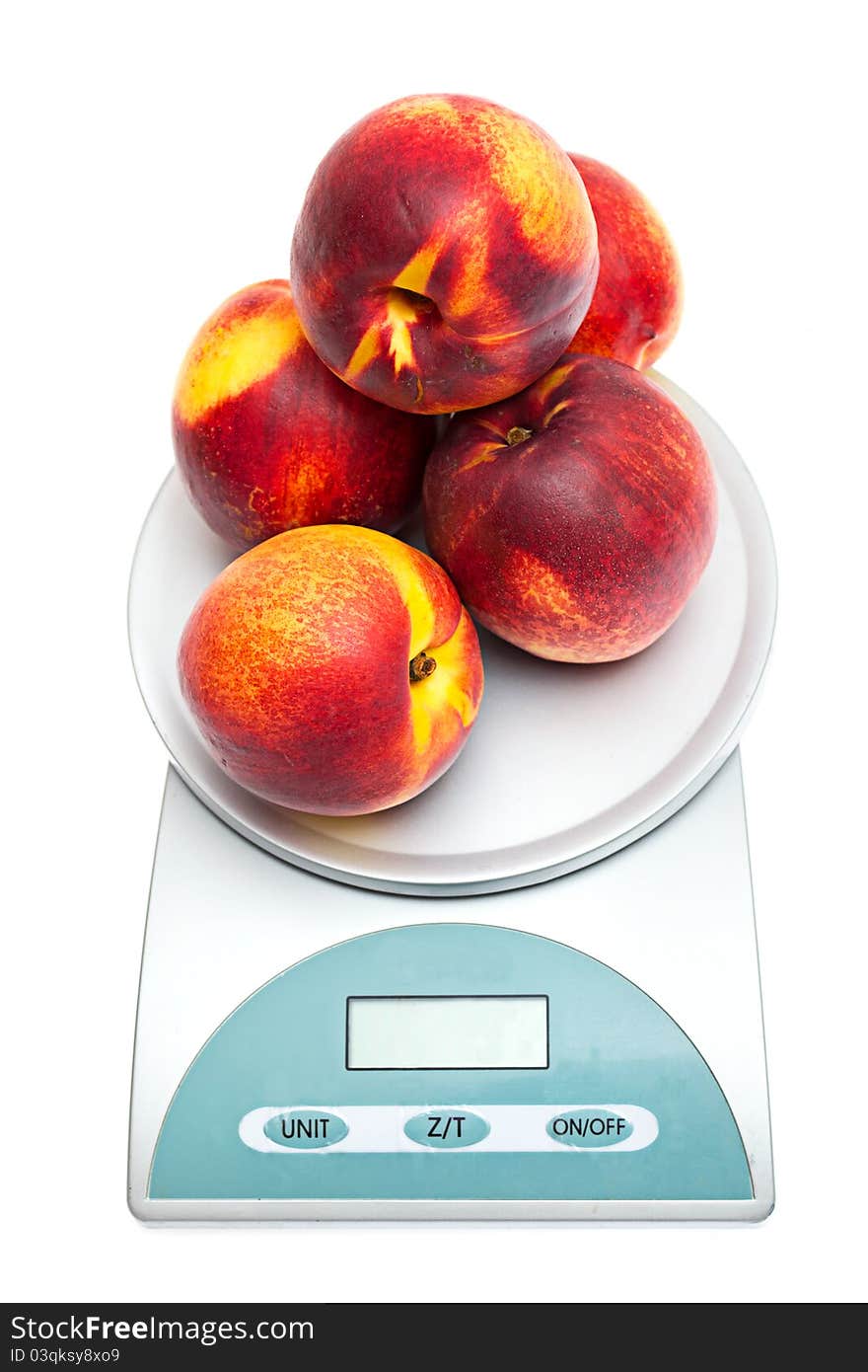 Peaches on the scales on a white background