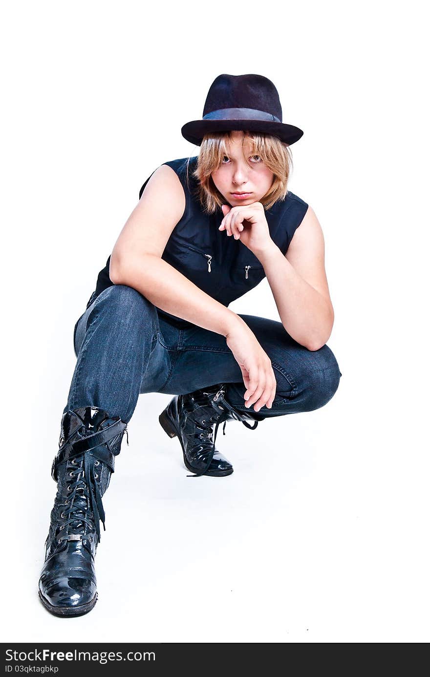 Blond girl in jeans, hat and black jacket looking at camera