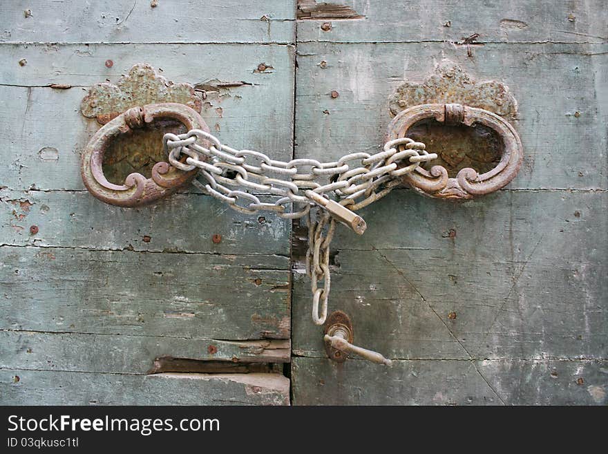 Detail of an old doorway with handles chain and padlock