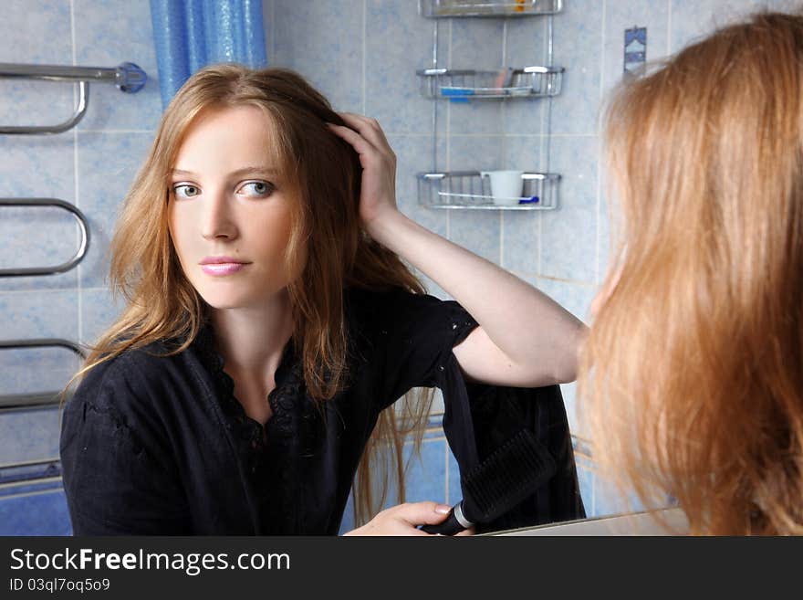 Young woman in bath at front of a mirror