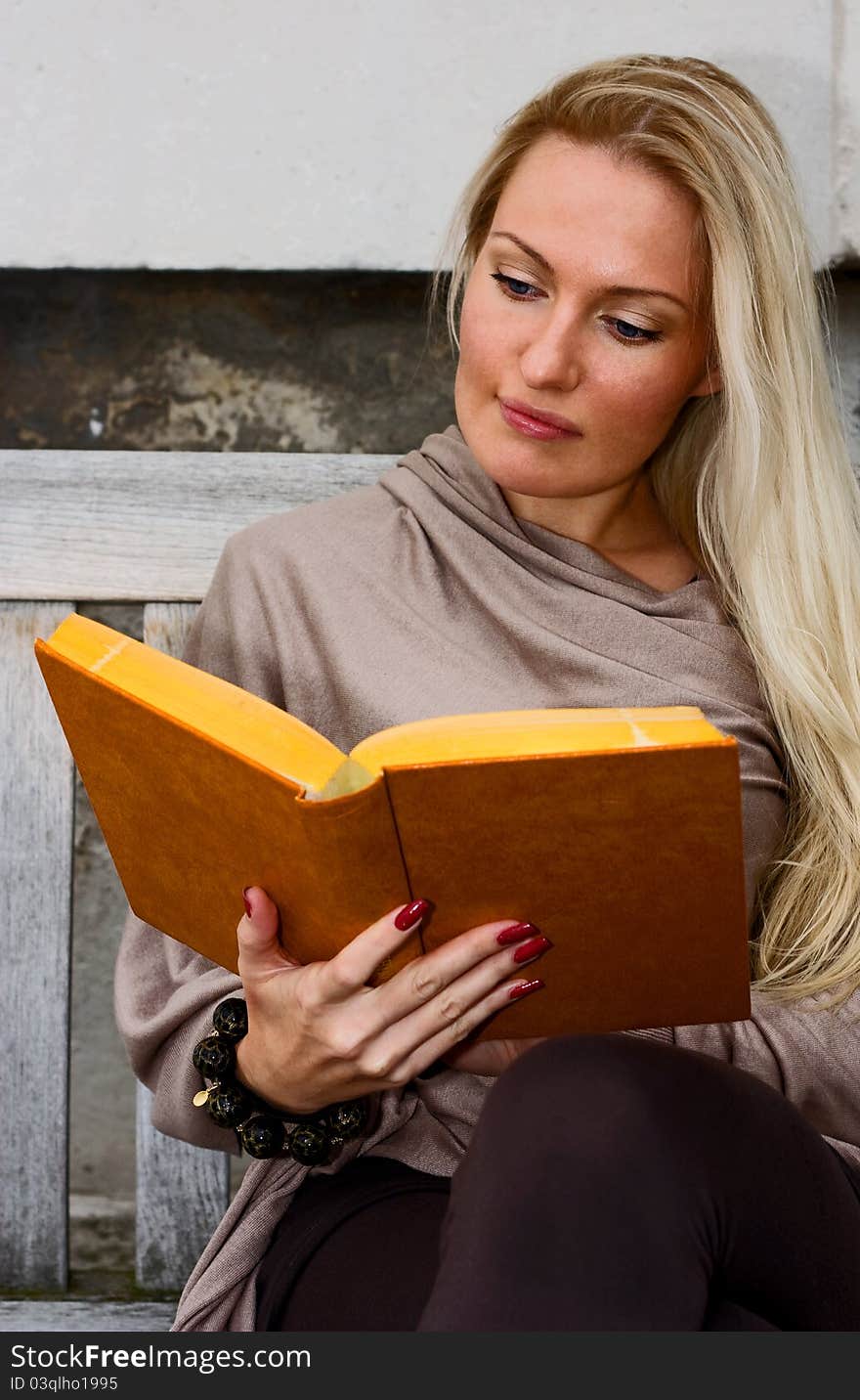 Woman sitting on a bench reading. Woman sitting on a bench reading.