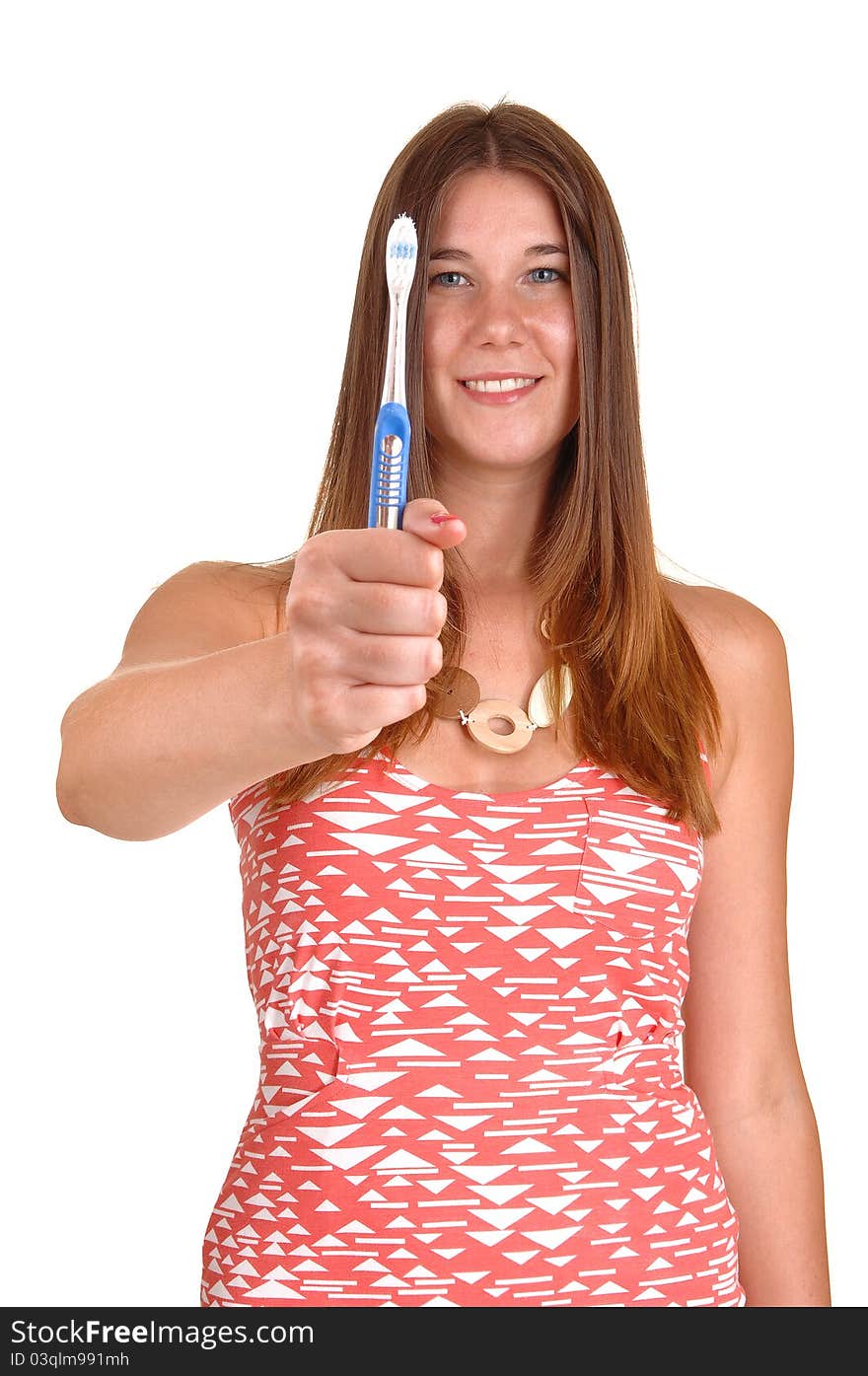 A young and happy woman showing her blue toothbrush, telling that she is brushing her teeth regularly, in white background. A young and happy woman showing her blue toothbrush, telling that she is brushing her teeth regularly, in white background.