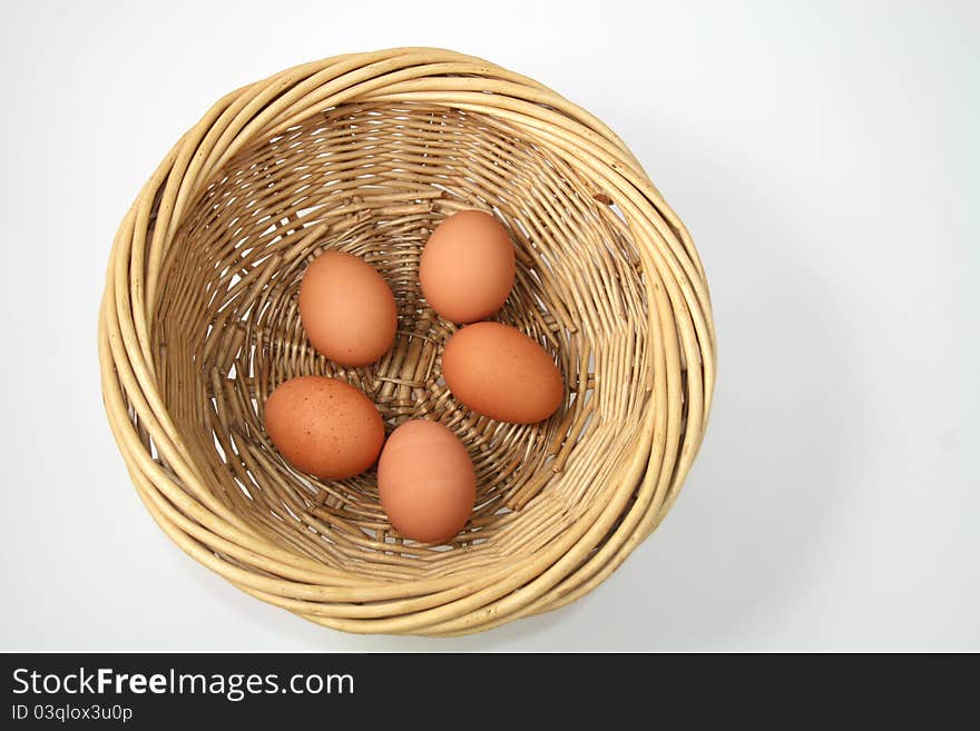 Five brown hens eggs in light brown wicker basket, on white background. Five brown hens eggs in light brown wicker basket, on white background.