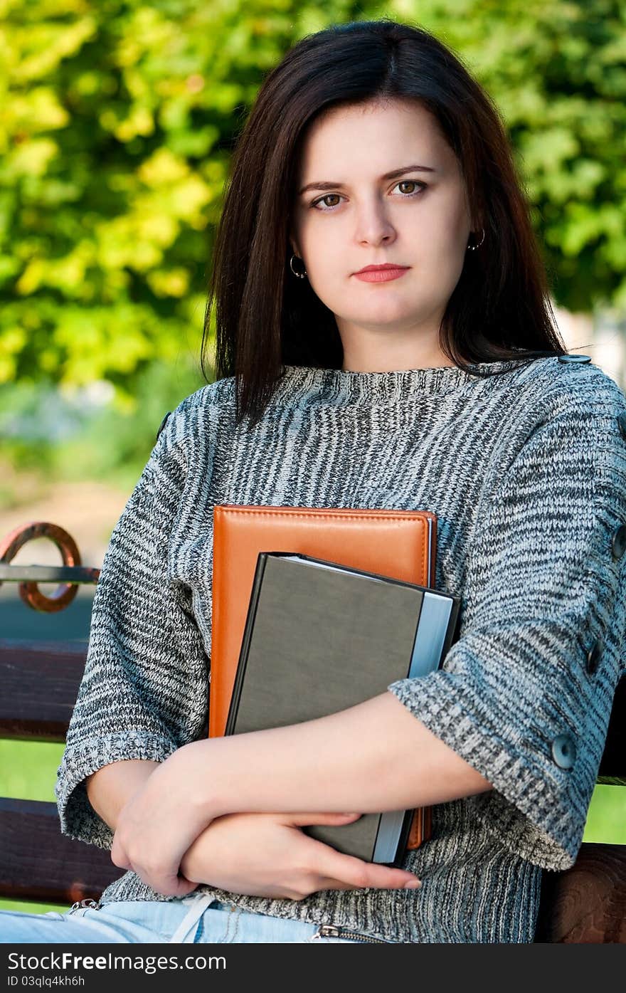 Portrait of a young female student with books at the campus