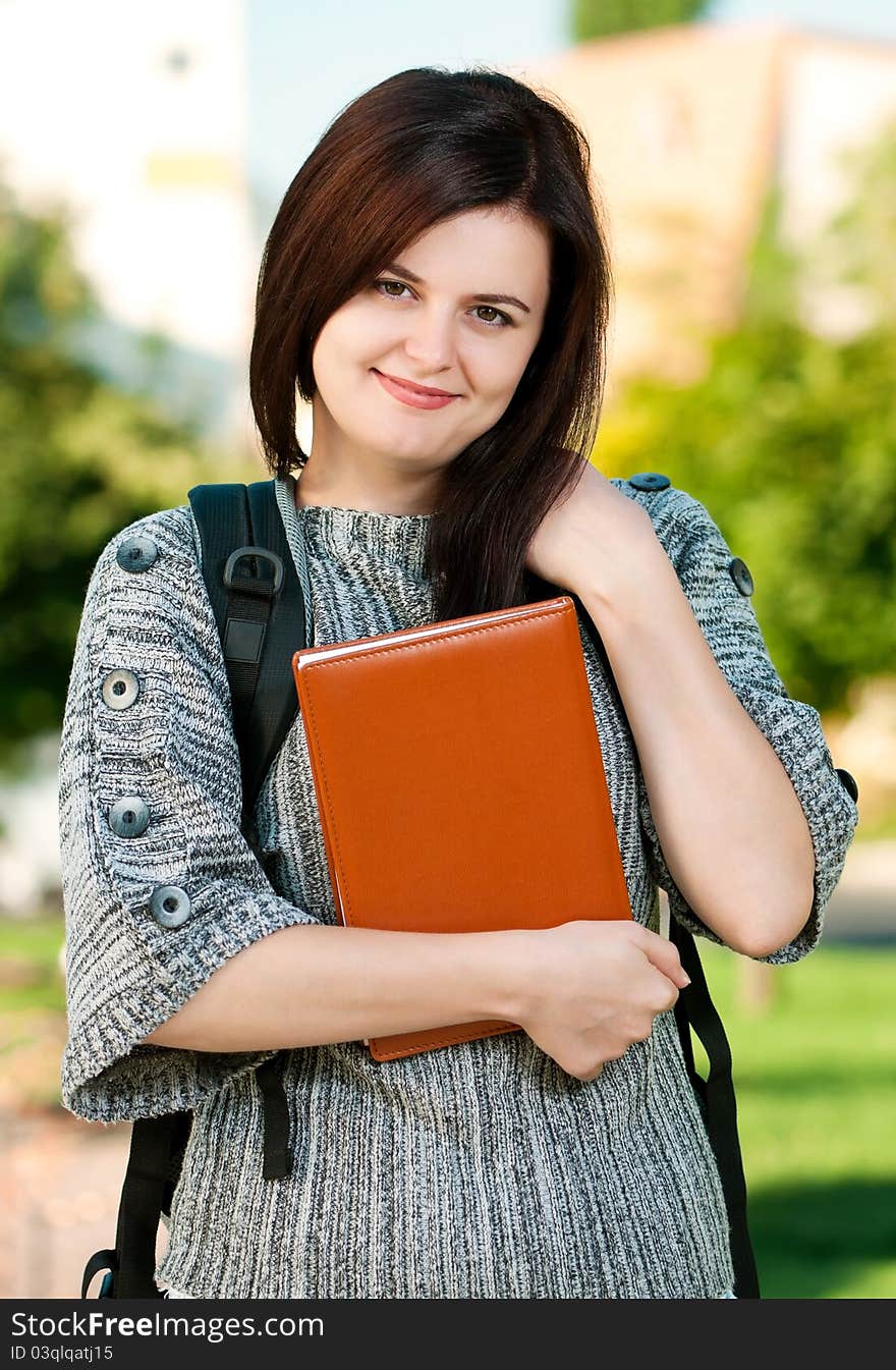 Portrait of a young female student with books at the campus