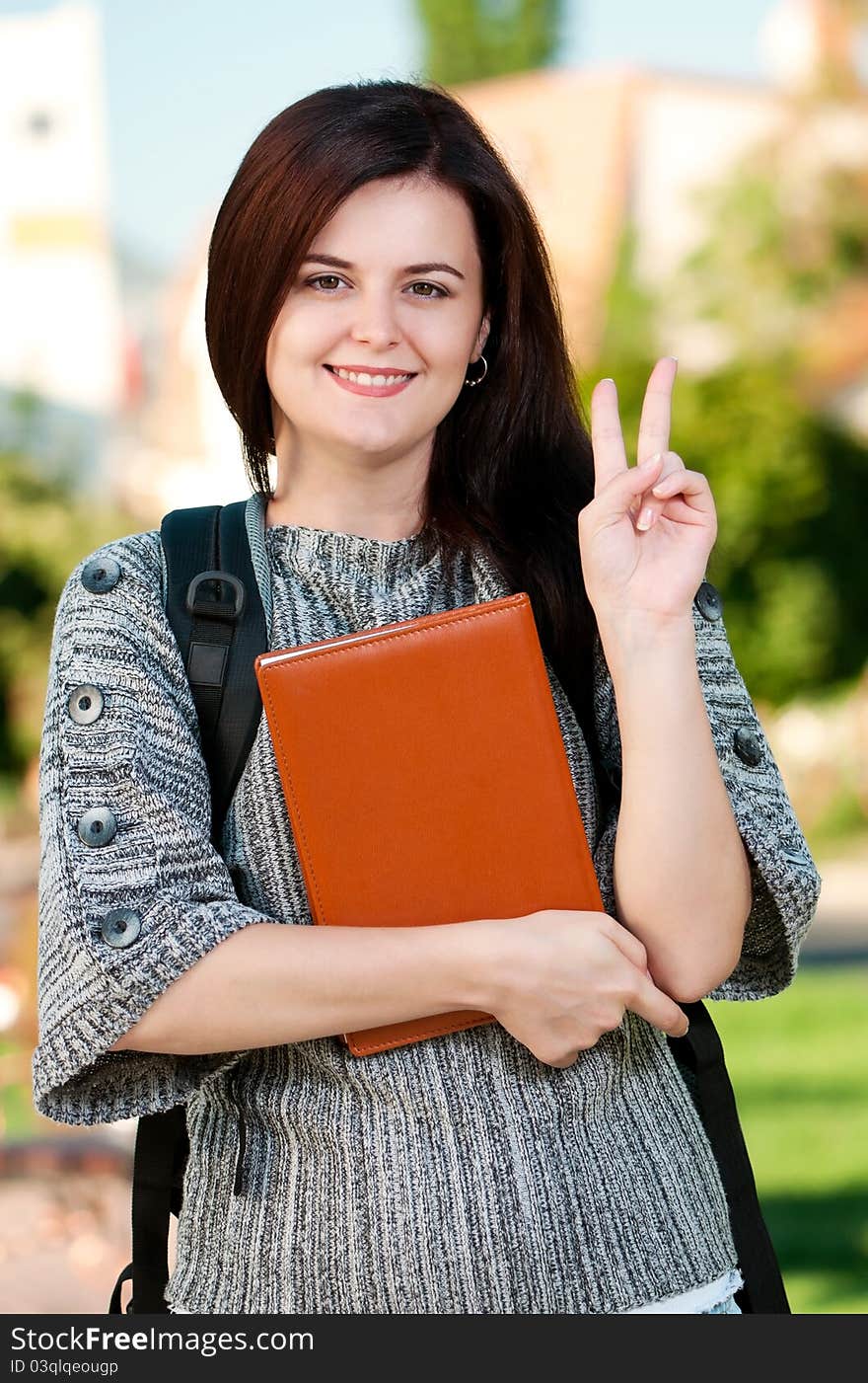 Portrait of a young female student with books at the campus