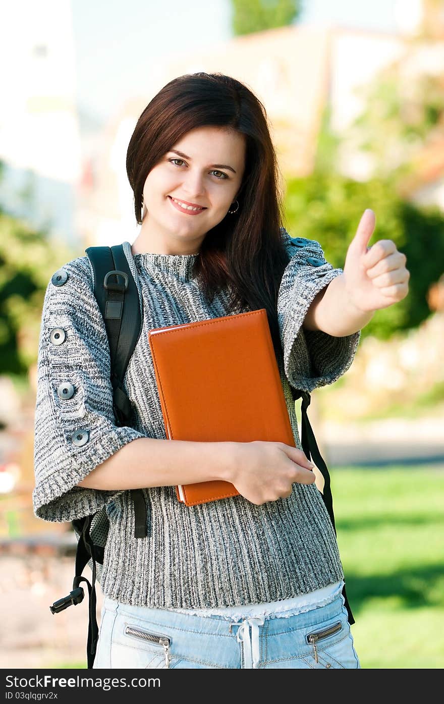 Portrait of a young female student with books at the campus