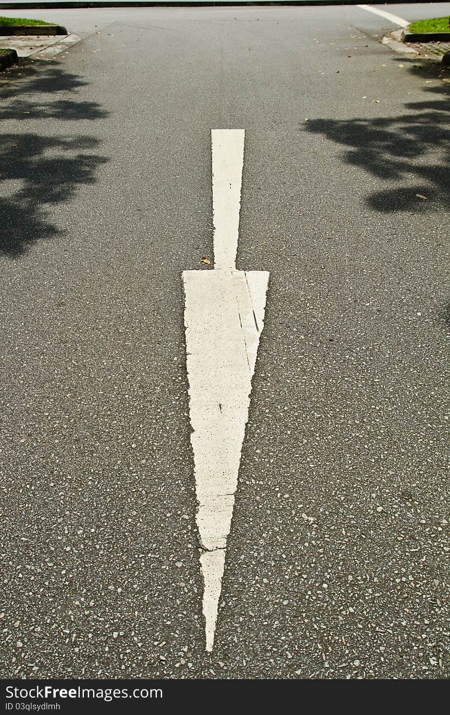 An empty street with a downward pointing white arrow. An empty street with a downward pointing white arrow