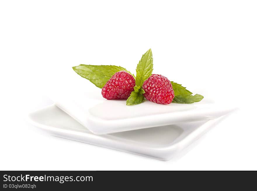 Raspberries in a white plate on a white background. Raspberries in a white plate on a white background