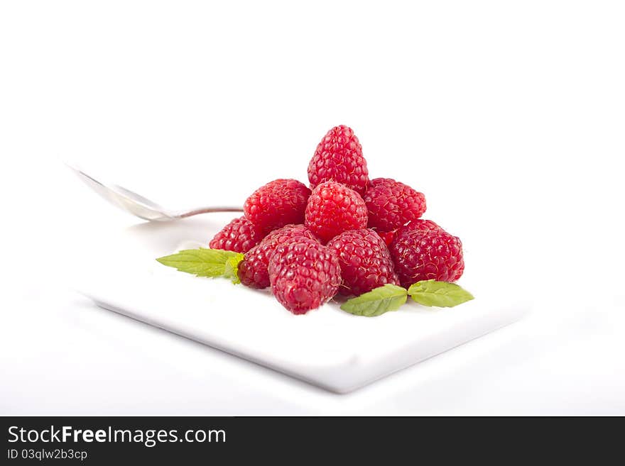 Raspberries in a white plate on a white background. Raspberries in a white plate on a white background