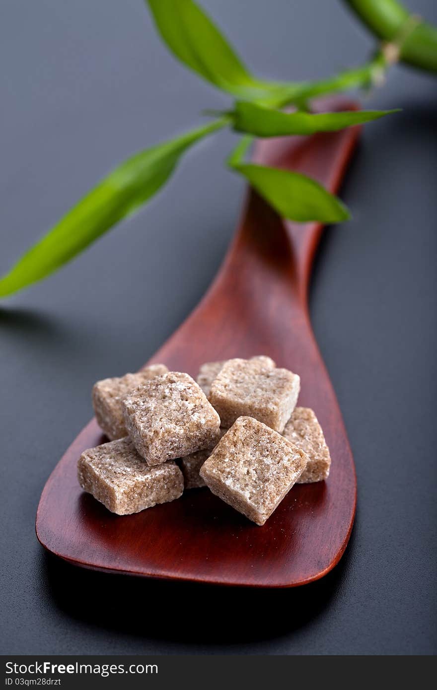 Wooden spoon with brown sugar cubes