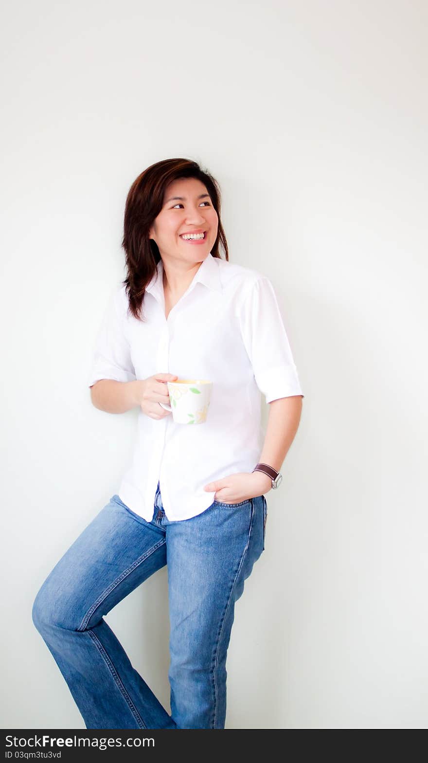 Smiling young asian woman holding a cup