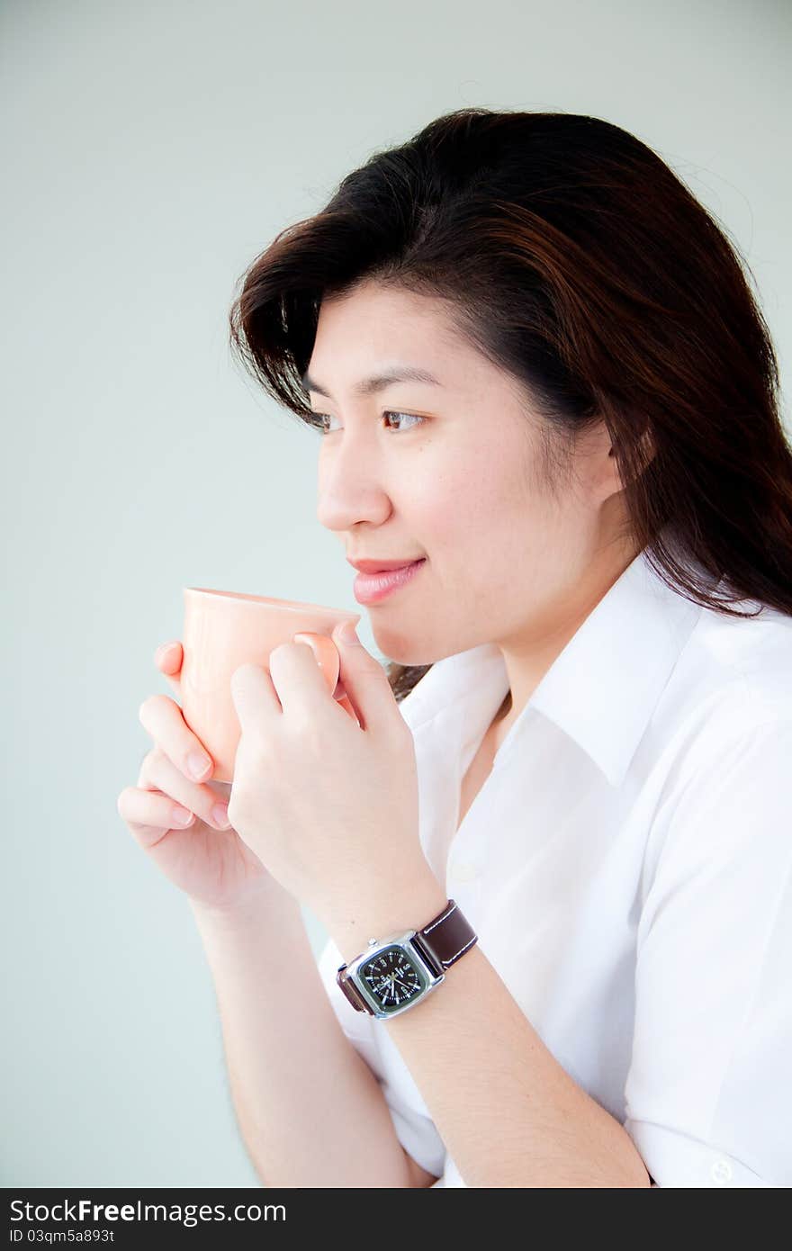 Smiling young asian woman holding a cup