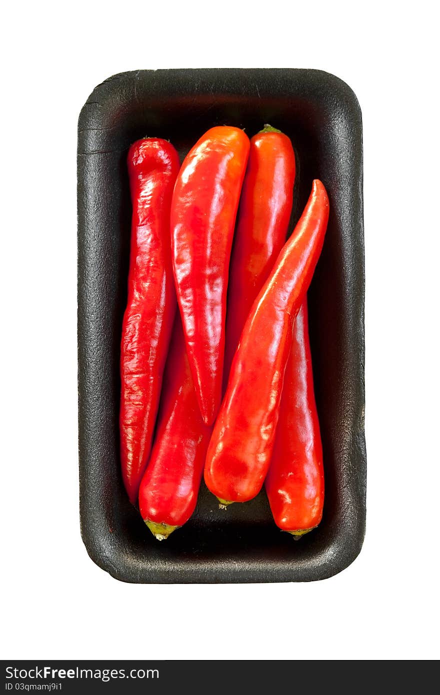 Red chili on black tray isolated on white background