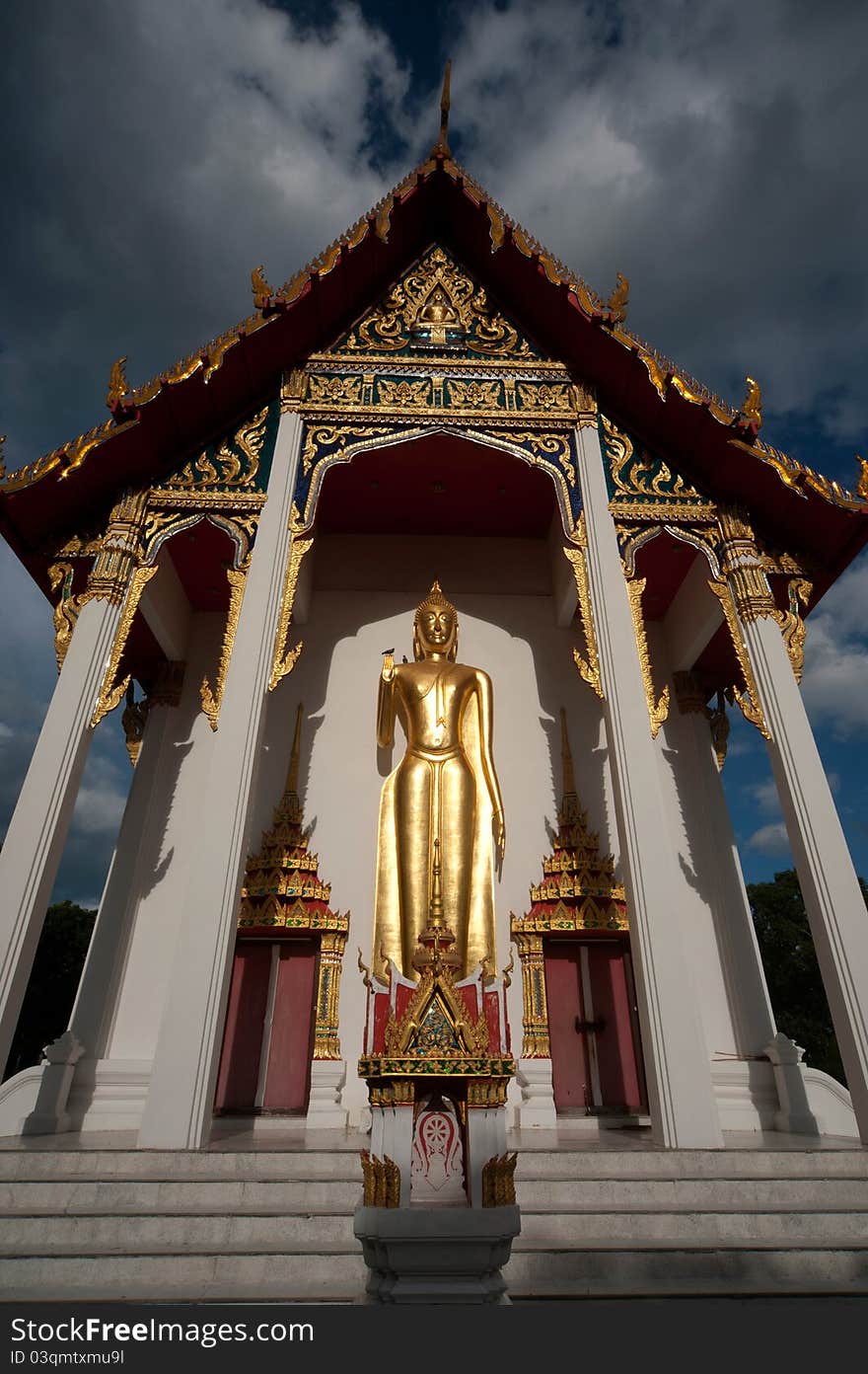 Golden stand big Buddha at front of Thai church in temple. Golden stand big Buddha at front of Thai church in temple.