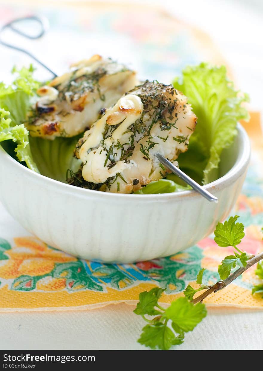 A grilled fish fillet with lettuce. Shallow depth, selective focus. A grilled fish fillet with lettuce. Shallow depth, selective focus