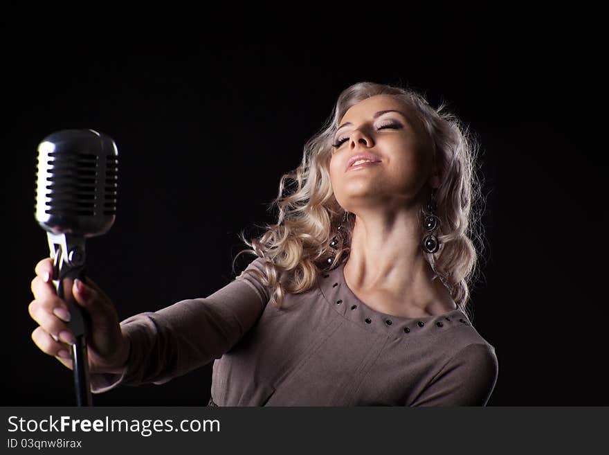 Beautiful blond woman portrait sing in microphone