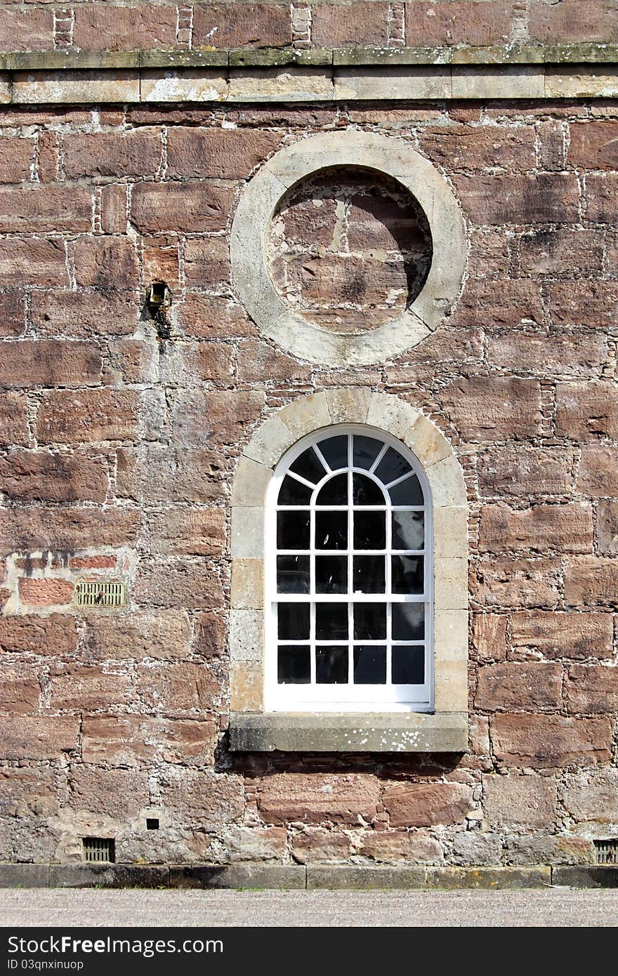 Detail of wall and window on large brick building. Detail of wall and window on large brick building