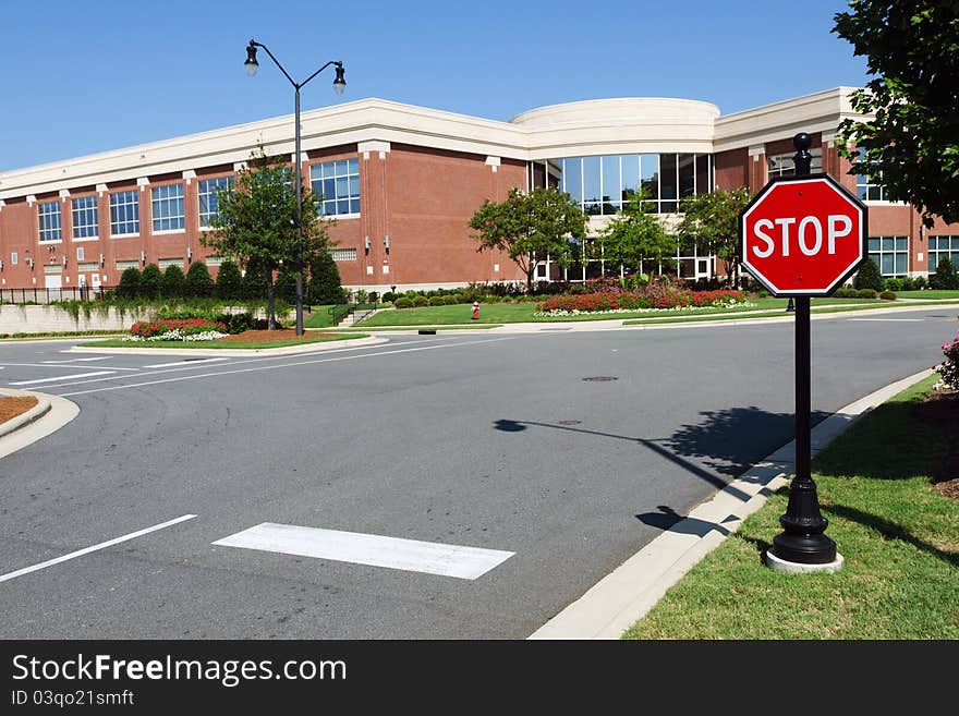 Road intersection with stop sign near Medical mixed-use office building in american suburban area. Road intersection with stop sign near Medical mixed-use office building in american suburban area