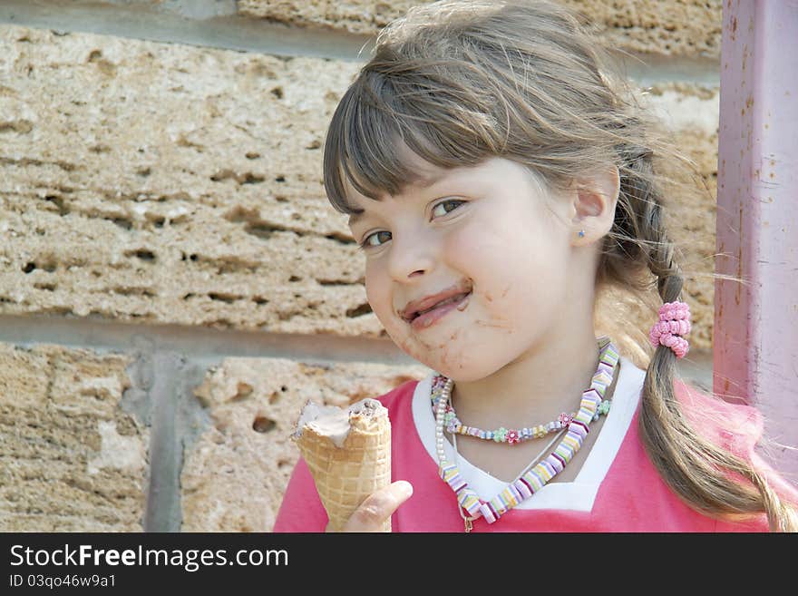 The soiled child holds ice-cream in a hand and artfully looks forward. The soiled child holds ice-cream in a hand and artfully looks forward