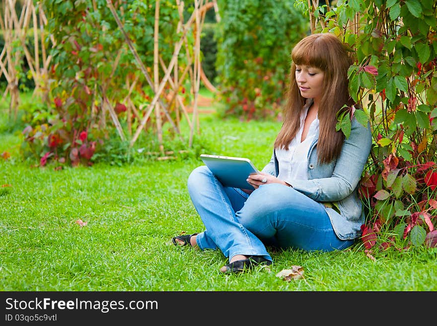 Young woman reading in tablet pc in the park