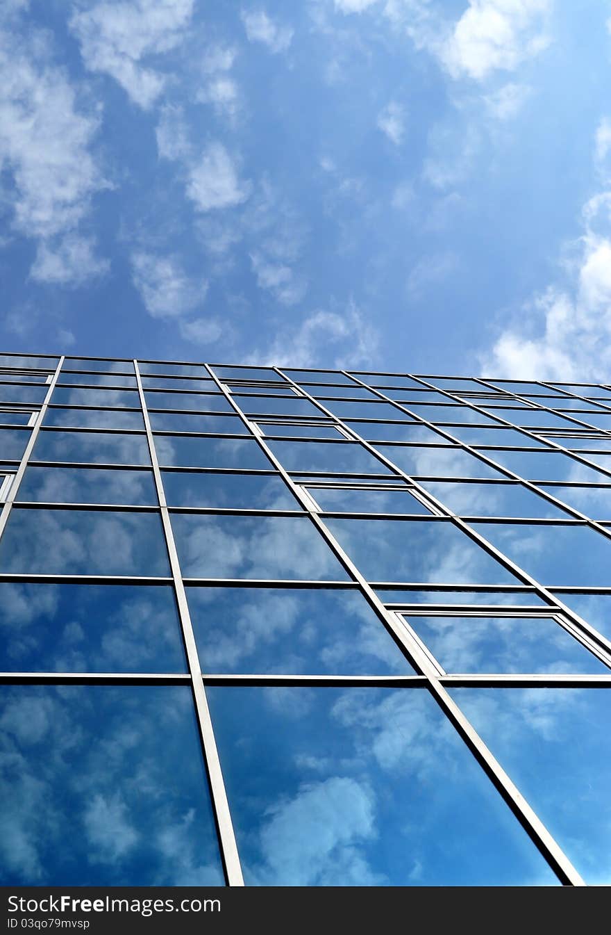 High-rise glass building with sky and clouds reflection. High-rise glass building with sky and clouds reflection