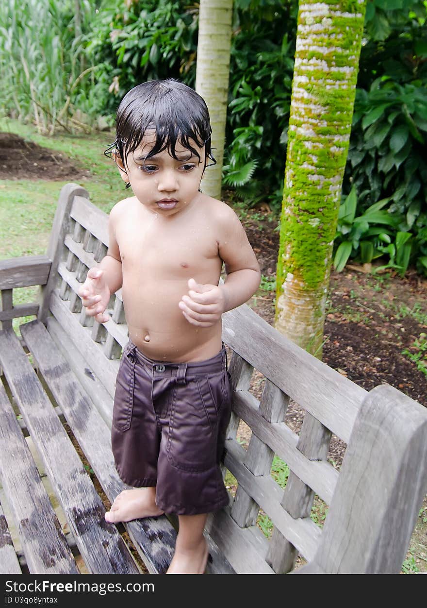 Wet toddler boy standing after playing with water