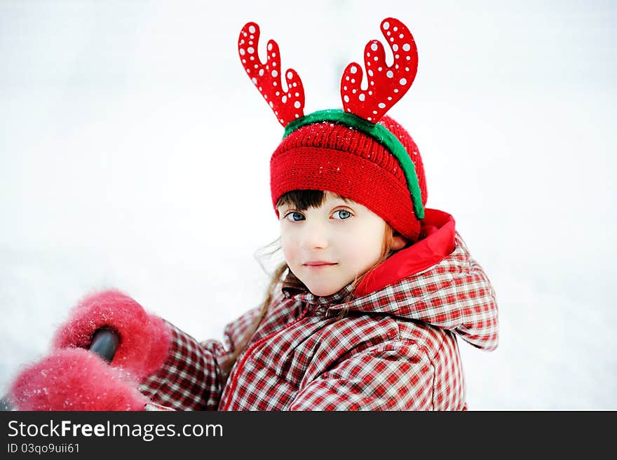 Outdoors portrait of adorable child girl in Christmas outfit. Outdoors portrait of adorable child girl in Christmas outfit