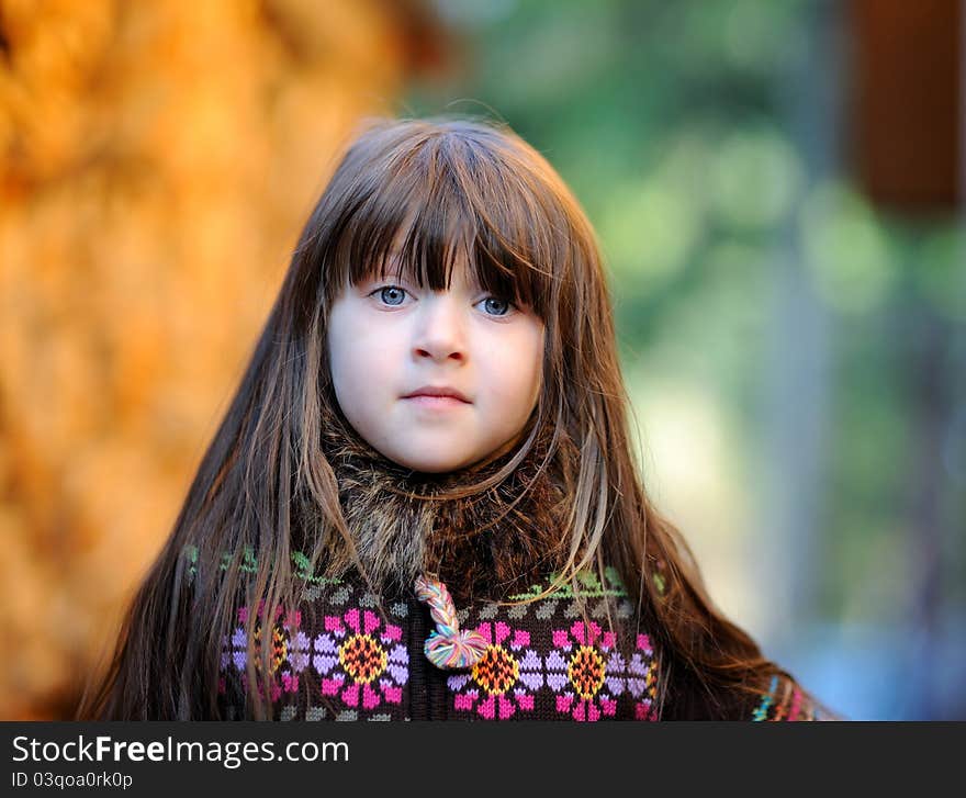 Outdoors portrait of adorable little brunette girl with loose hair. Outdoors portrait of adorable little brunette girl with loose hair