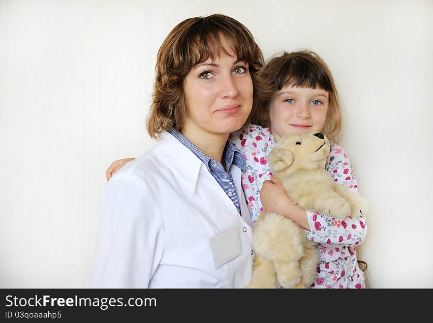 Young female doctor with a cute little patient on a white background