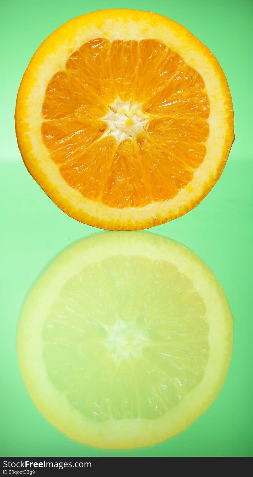 Orange slice on green background reflected in glass