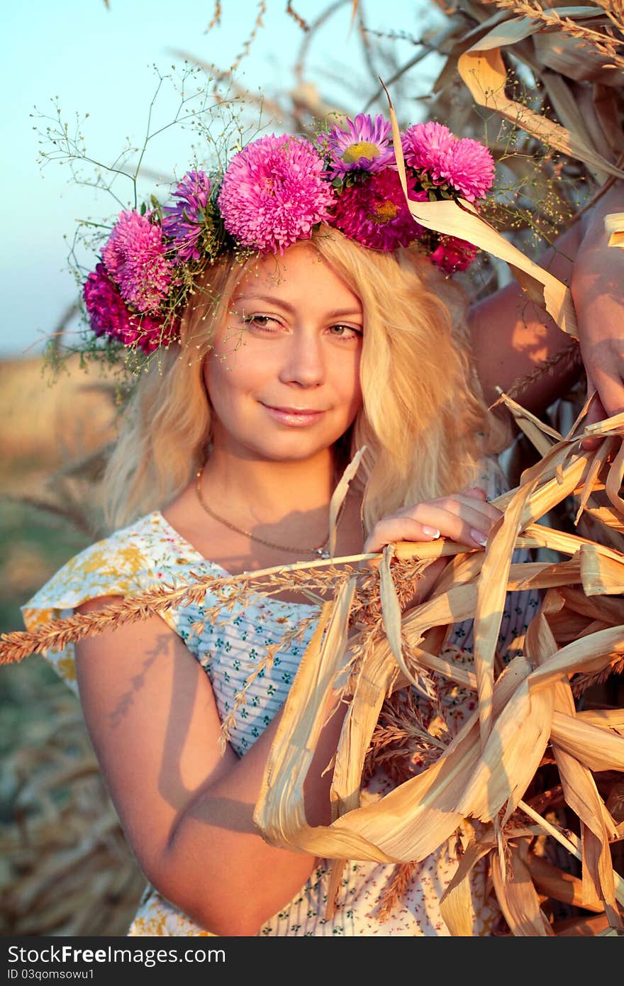 Young woman in corn haystack with wreath