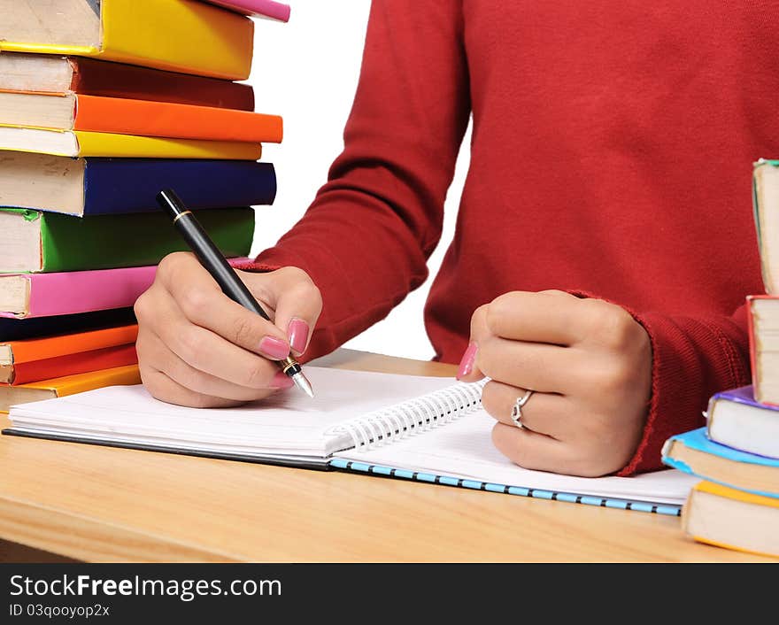 writing and clench her hands in a pile of colorful books